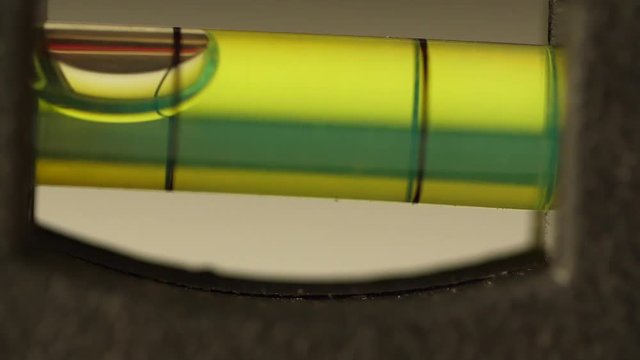 Carpenter's spirit level close up. Measuring the flatness with a spirit level. Level bubble up macro