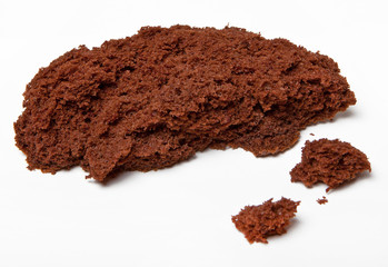 A piece of broken chocolate cake on white background