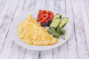Omlet with vegetable on the wood table