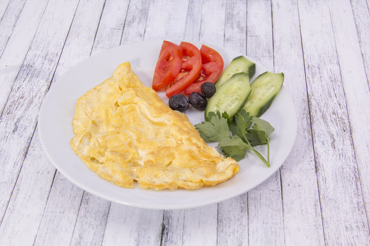 Omlet with vegetable on the wood table