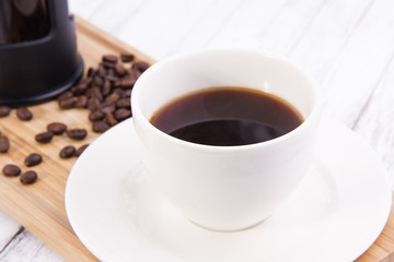 Coffee cup and beans on the wood table