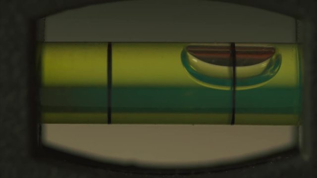 Carpenter's spirit level close up. Measuring the flatness with a spirit level. Level bubble up macro