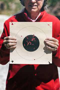 Shooting: Woman Holds Up Target With Many Bullseye Hits