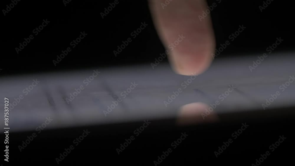 Poster macro clos-eup finger touching tablet computer touchscreen. fingers scrolling news feed on touchscre