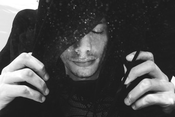 Beautiful man dressed in black floating in the pool