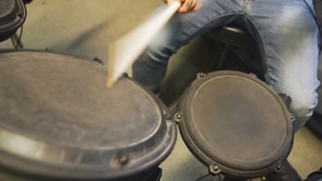 Drummer jamming on his electric drums, playing especially snare drum and tom-toms.