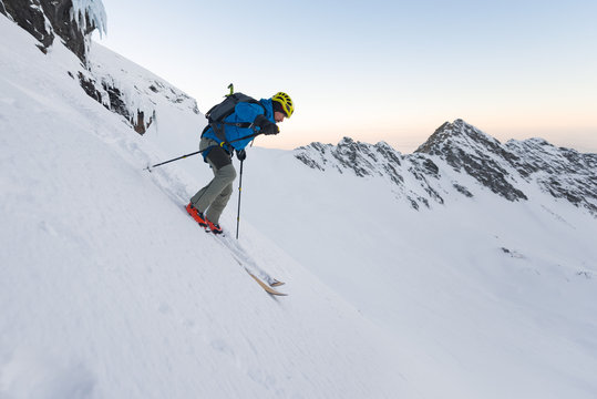 Man skiing off piste downhill steep slope
