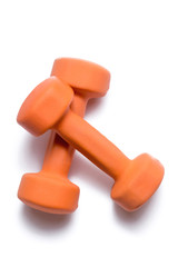 Two orange dumbbells lie on top of each other on a white background
