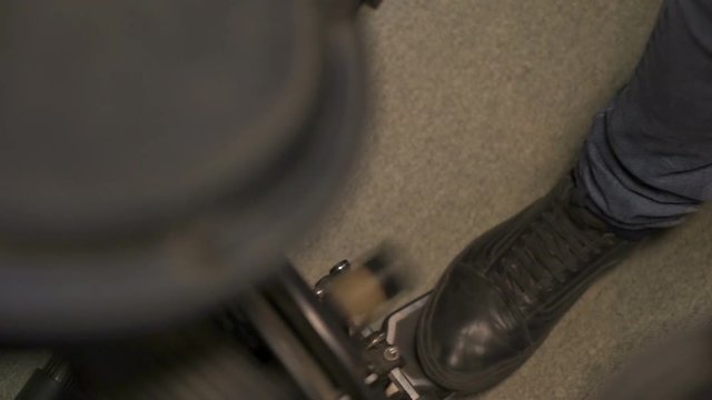 Drummer's foot pressing the electric bass drum pedal.