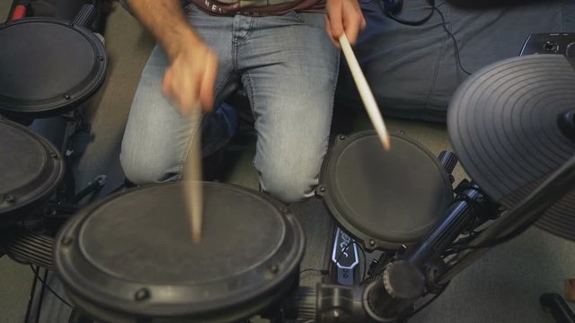 Drummer jamming on his electric drums, camera moves from left to right.