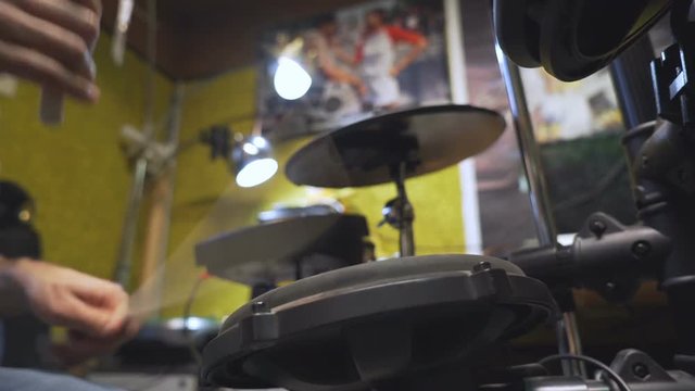 Drum sticks beating on electric drums, filmed in low angle.