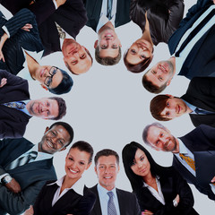 Group of business people standing in huddle, smiling, low angle view.