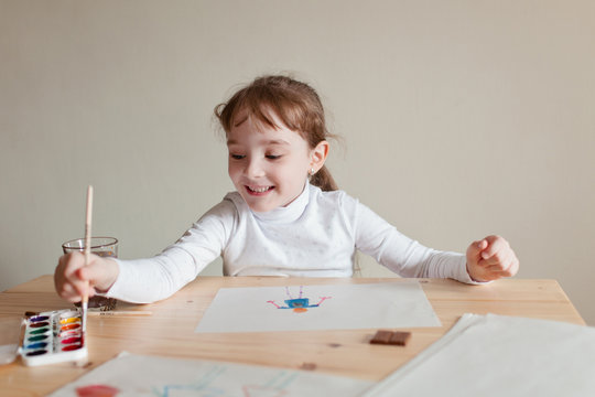 Cute little preschooler child drawing at home