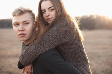 Young woman and man having fun outdoors at sunset light.