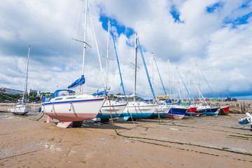 Fototapeta na wymiar Boats in the bay at low tide in Tenby bay, Wales