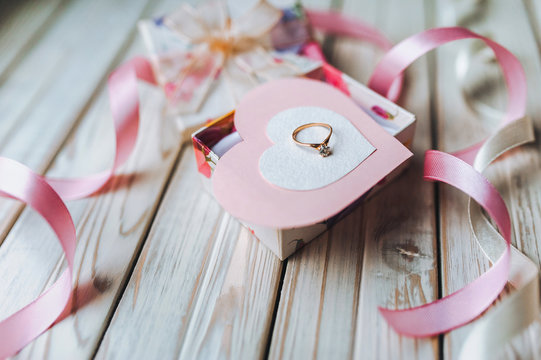 Marriage proposal concept. A wedding ring in a gift box on a wooden background. Valentine's Day.