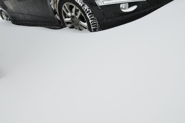 Part of the car with winter tyres on the snow