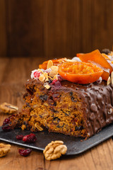 Cut traditional christmas fruit cake pudding in chocolate glaze