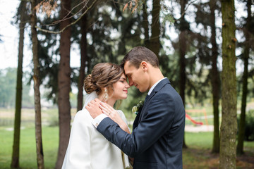 Just married couple dancing valse outdoor, free space. Bride and groom hugs, blurred green grass...
