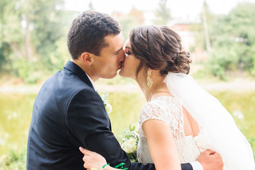 Beautifull wedding couple kissing and embracing outdoor. One beautiful wedding day