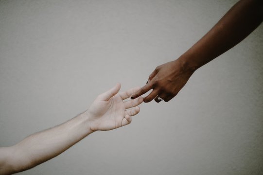 Reaching hands of black and caucasian race