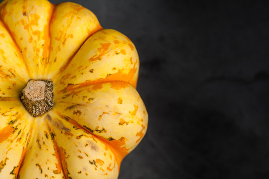 Orange and Yellow Sweet Dumpling Squash on slate background with copy space