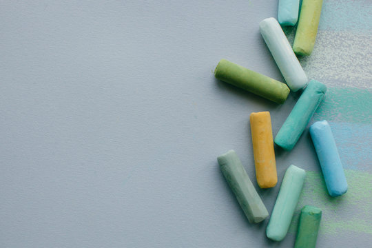 From above horizontal shot of soft pastel sticks on grey paper