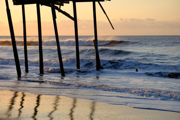Storm battered broken down pier at sunrise on the Atlantic ocean off the North Carolina Coast on...