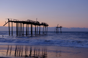 Storm battered broken down pier at sunrise on the Atlantic ocean off the North Carolina Coast on...