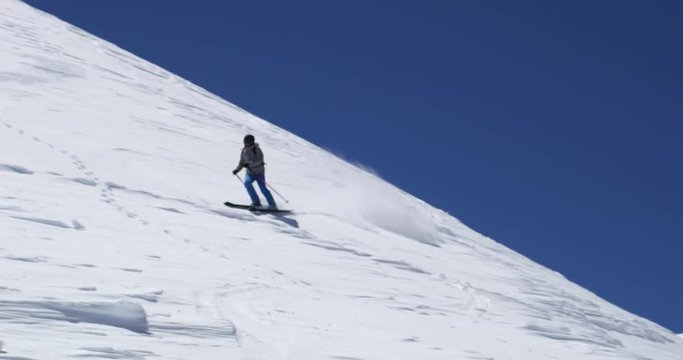 Man freeride skiing down snowy mount ridge in sunny day.Mountaineering ski activity. Skier people winter snow sport in alpine mountain outdoor.Front view.Slow motion 60p 4k video