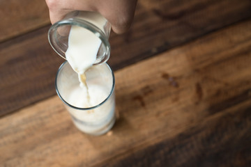 close up - pouring milk into glass. filling a glass with milk.