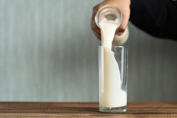pouring milk into glass. filling a glass with milk.