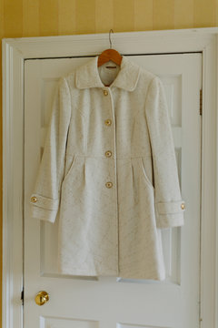 White Jacket with Gold Buttons Hanging on Door Frame