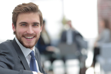 Successful business man standing with his staff in background at