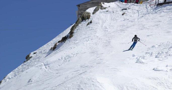 Man freeride skiing down snowy mount ridge in sunny day.Mountaineering ski activity. Skier people winter snow sport in alpine mountain outdoor.Front view.Slow motion 60p 4k video