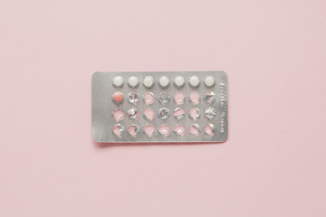 Contraceptive pills blister over pink background