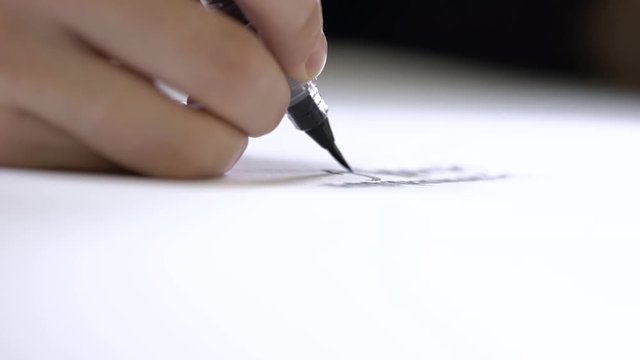 Hand writing calligraphically with a brush on paper.