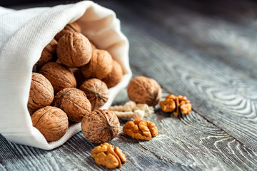 Walnuts in sack on wooden backgound