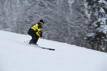 Fototapeta na wymiar Skier on piste running downhill