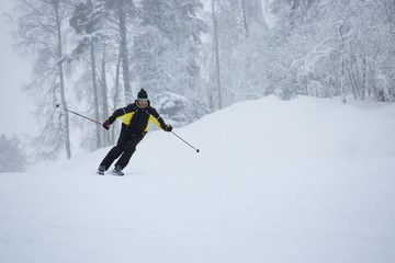 Fototapeta na wymiar Skier on piste running downhill