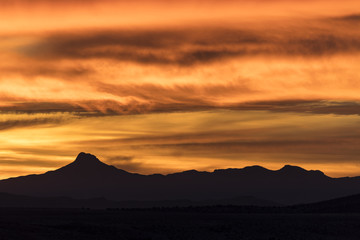 An intense fiery sunrise over a beautiful mountain in the desert  