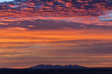 beautiful sunrise over some distant desert mountains