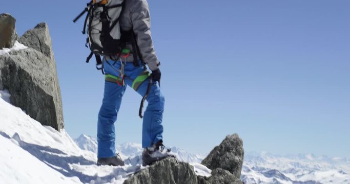 Climber mountaineer man reaching snowy mount top with ice axe in sunny day.Mountaineering ski activity. Skier people winter snow sport in alpine mountain outdoor.Back view.Slow motion 60p 4k video