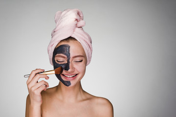 young girl with a towel on her head apply on face mask