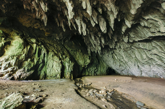 Mountain cave entrance with stalactites