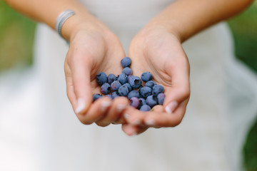 Bride Holding Handful of Blueberries