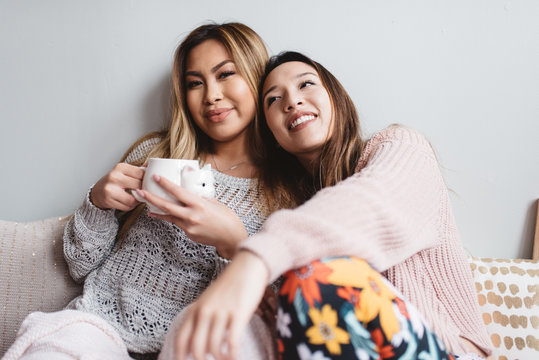 Two friends sitting in bed on a laptop