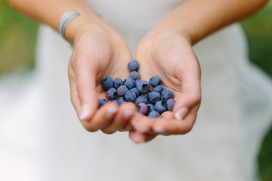 Bride Holding Handful of Blueberries