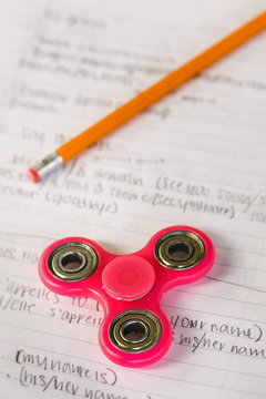Spinner: Fidget Toy Sits On Notebook Of French Class Notes