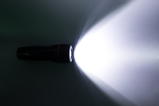 Beam of a flashlight on a white background, light and shadow concepts.